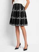 Black A-line skirt with an off-white etched plaid pattern. Knit fabric.