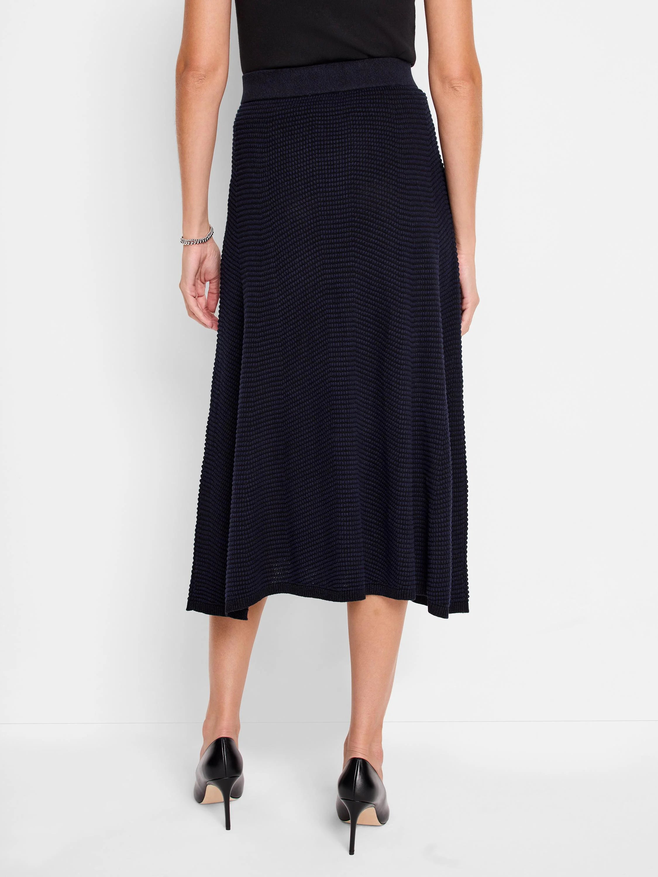 Dark navy blue midi-length knit skirt; textured, A-line silhouette.