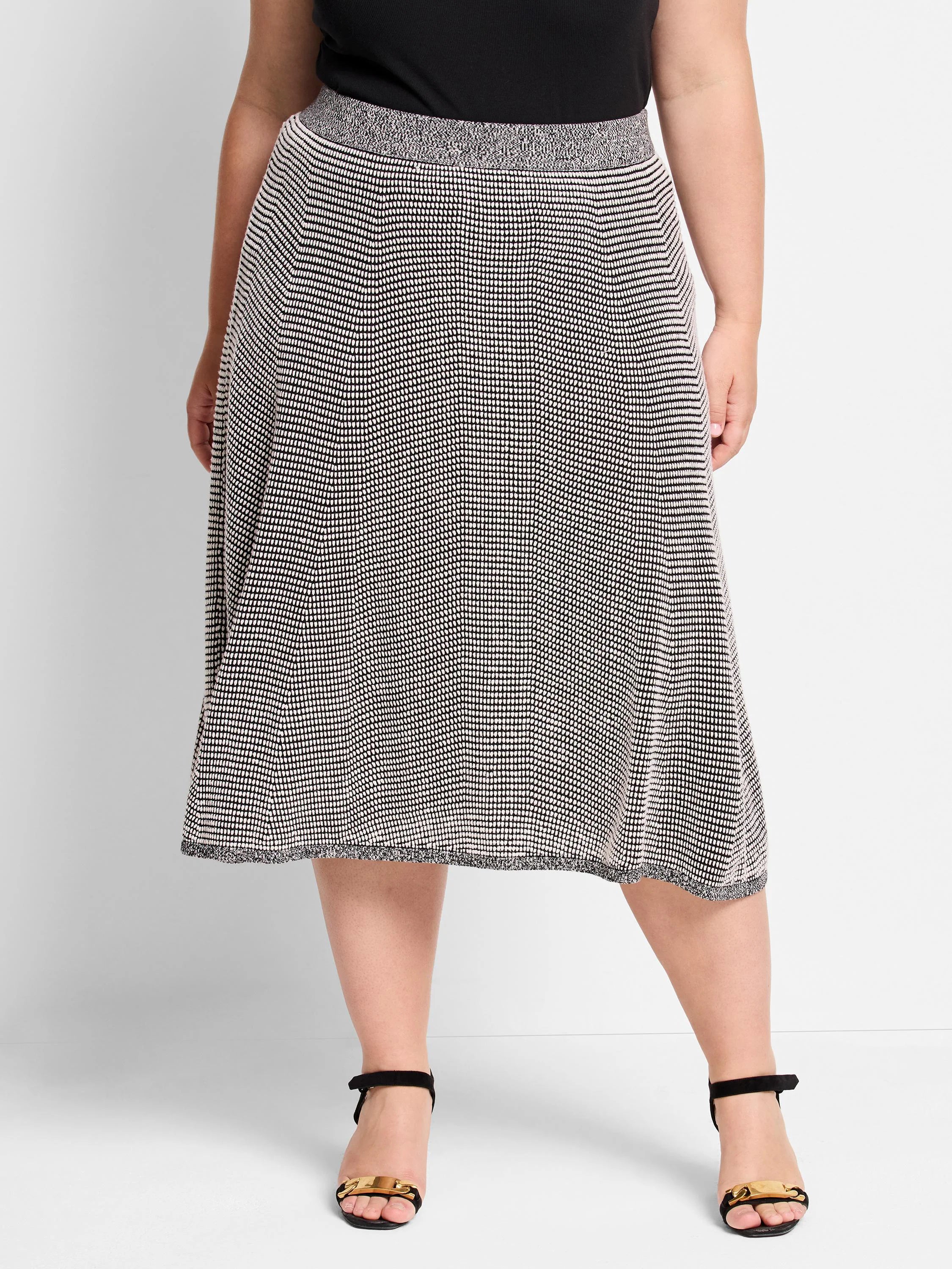 Black & white knit A-line skirt, knee-length. Features a pixel dot pattern and textured waistband/hem.
