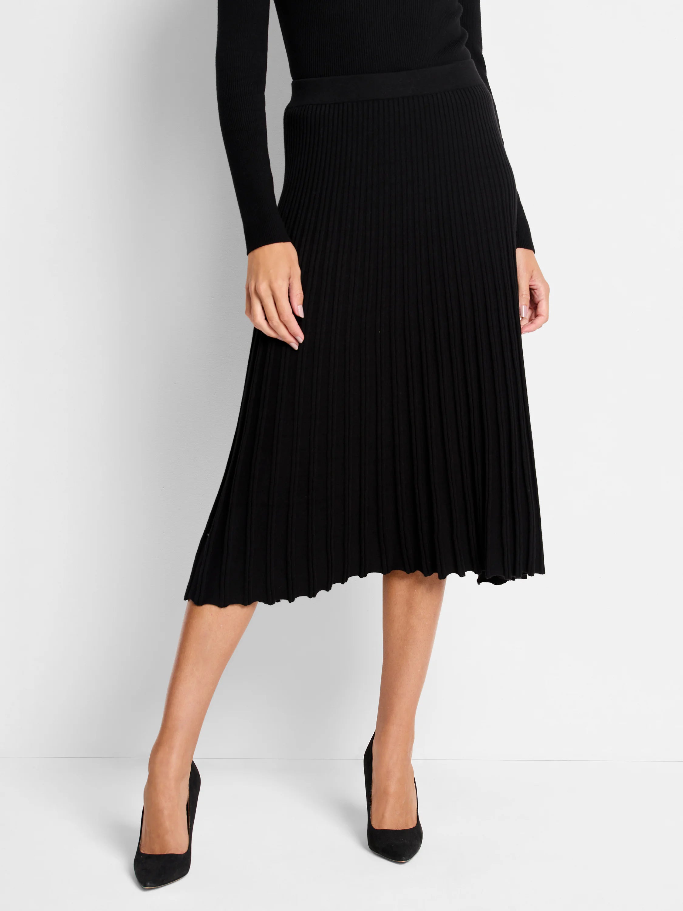 Black ribbed sweater knit midi skirt with an A-line silhouette and scalloped hem.