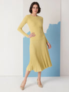 Pale yellow ribbed sweater skirt, midi-length, with vertical pleats.