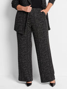 Black wide-leg pants with a small white grid pattern.  Model wears black shoes.
