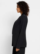 Black open blazer, long sleeves, collared.  Side profile view.