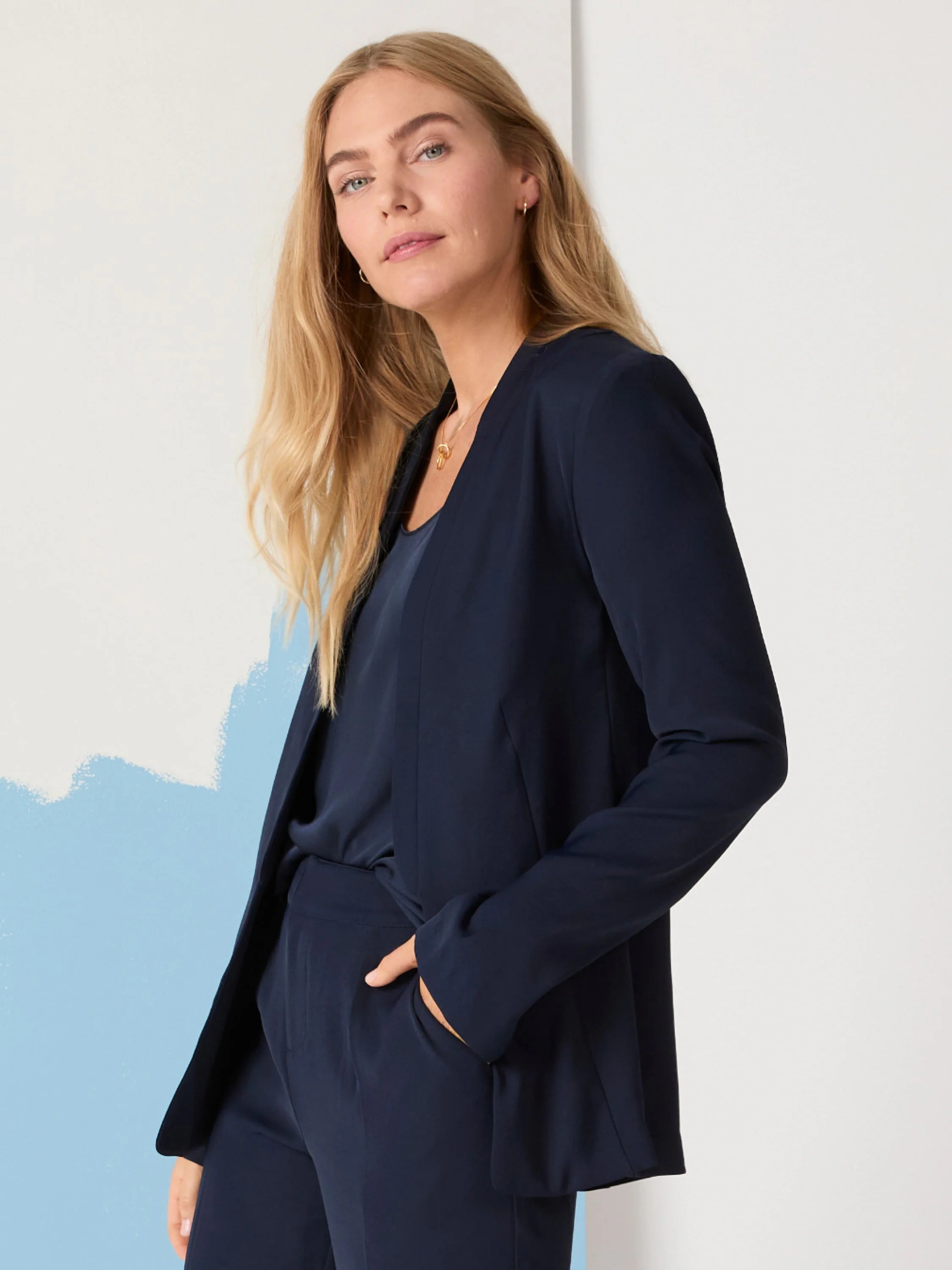 Navy blue open blazer, shown on model.  Long sleeves, no visible buttons or closures.