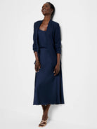 Navy blue blazer and midi skirt;  open collar; three-quarter sleeves.