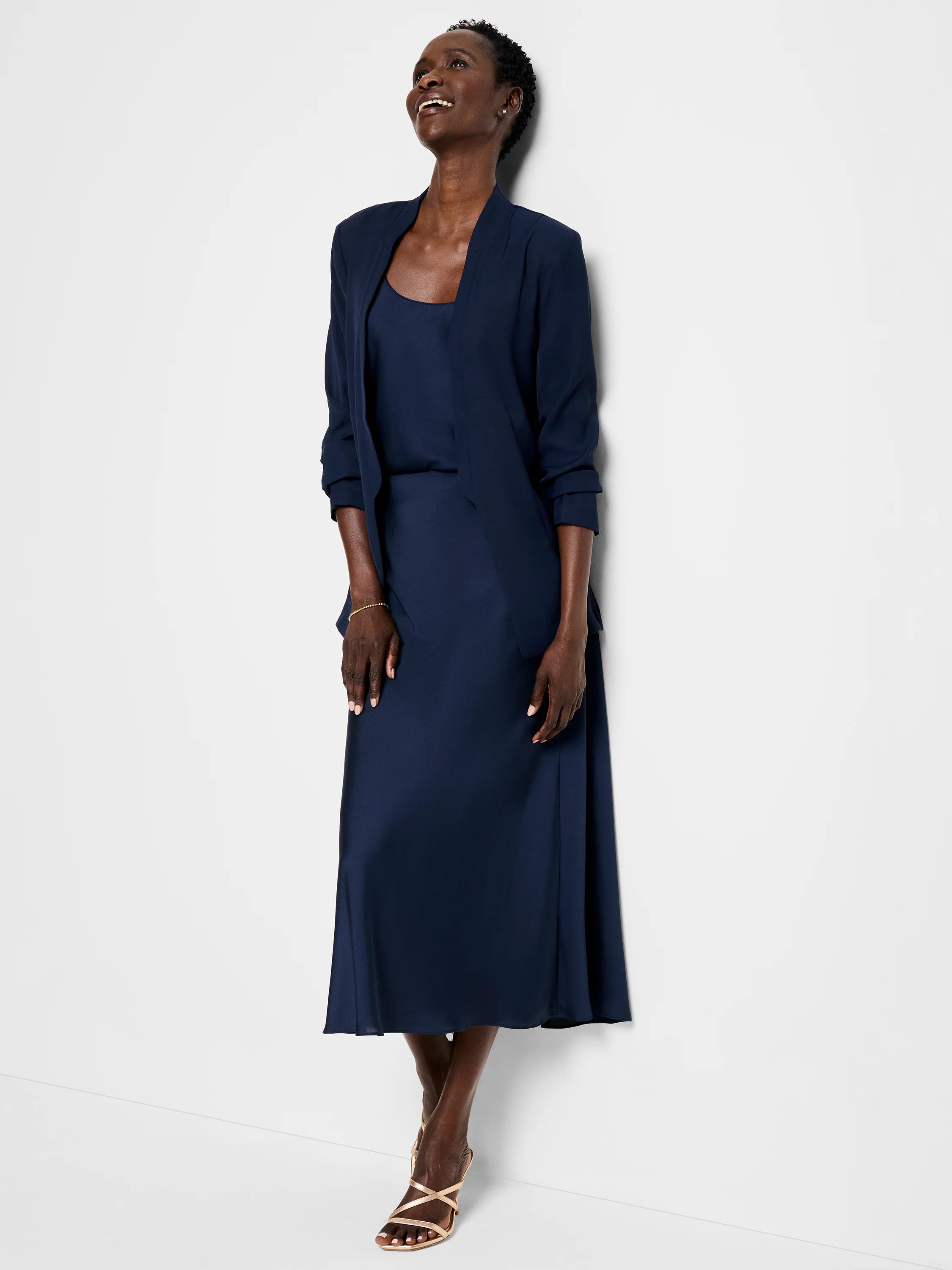 Navy blue blazer and midi skirt;  open collar; three-quarter sleeves.