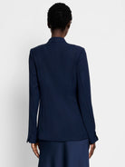 Dark navy blazer, long sleeves, back view.  Seamed detail at back.  Model wears matching skirt.