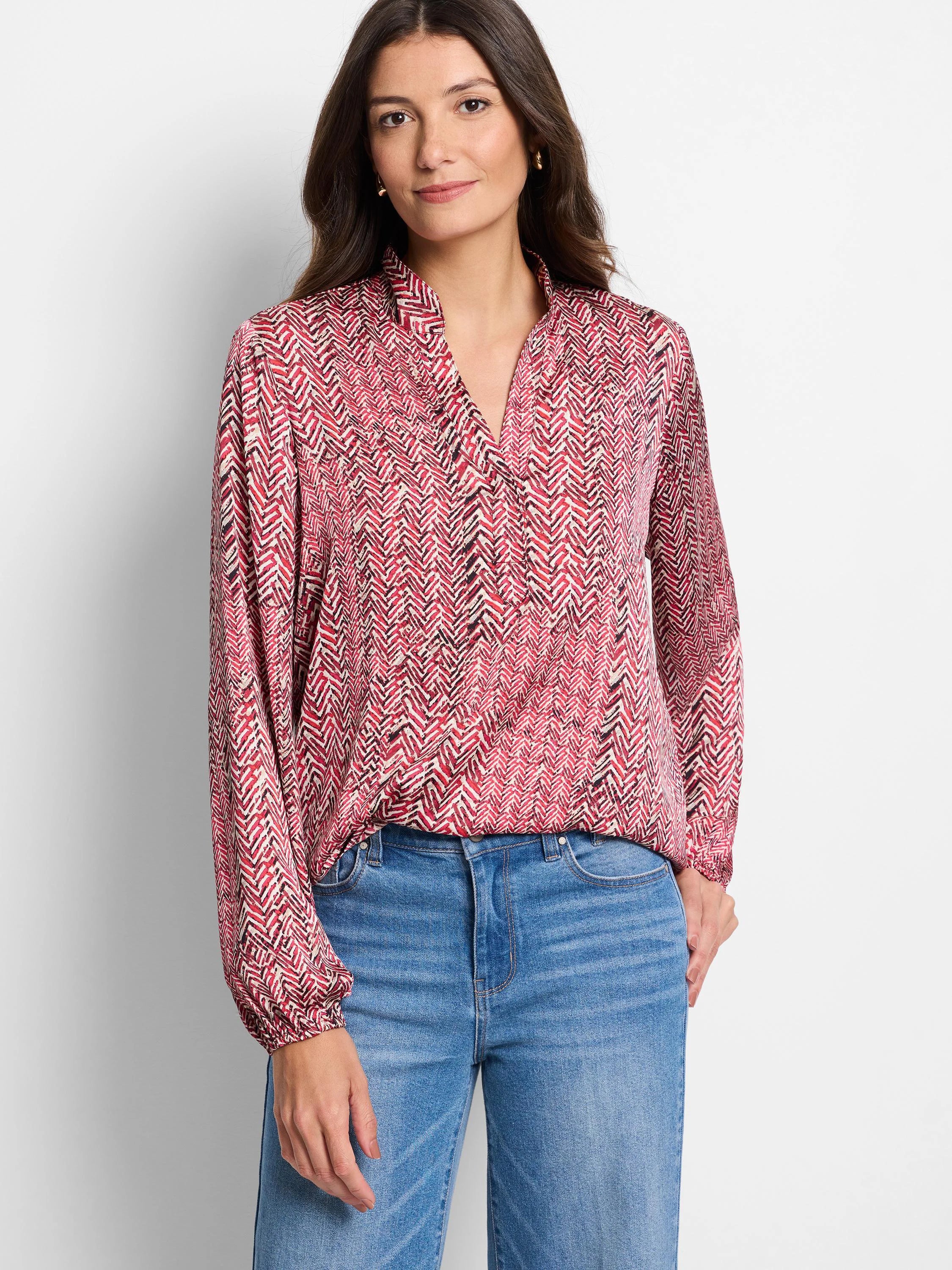 Red, cream, and black herringbone patterned long-sleeve blouse with a v-neck.