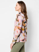Long-sleeve collared shirt with an abstract print in pink, orange, brown, and dark gray on a light background.