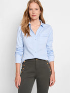 Light blue long-sleeve button-down shirt; two chest pockets.  Gold buttons.