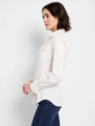 Off-white long-sleeve collared shirt with chest pocket; shown on model.