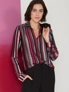 Long-sleeve shirt; vertical stripes in pink, red, teal, green, black, and gray on black background. Collared.