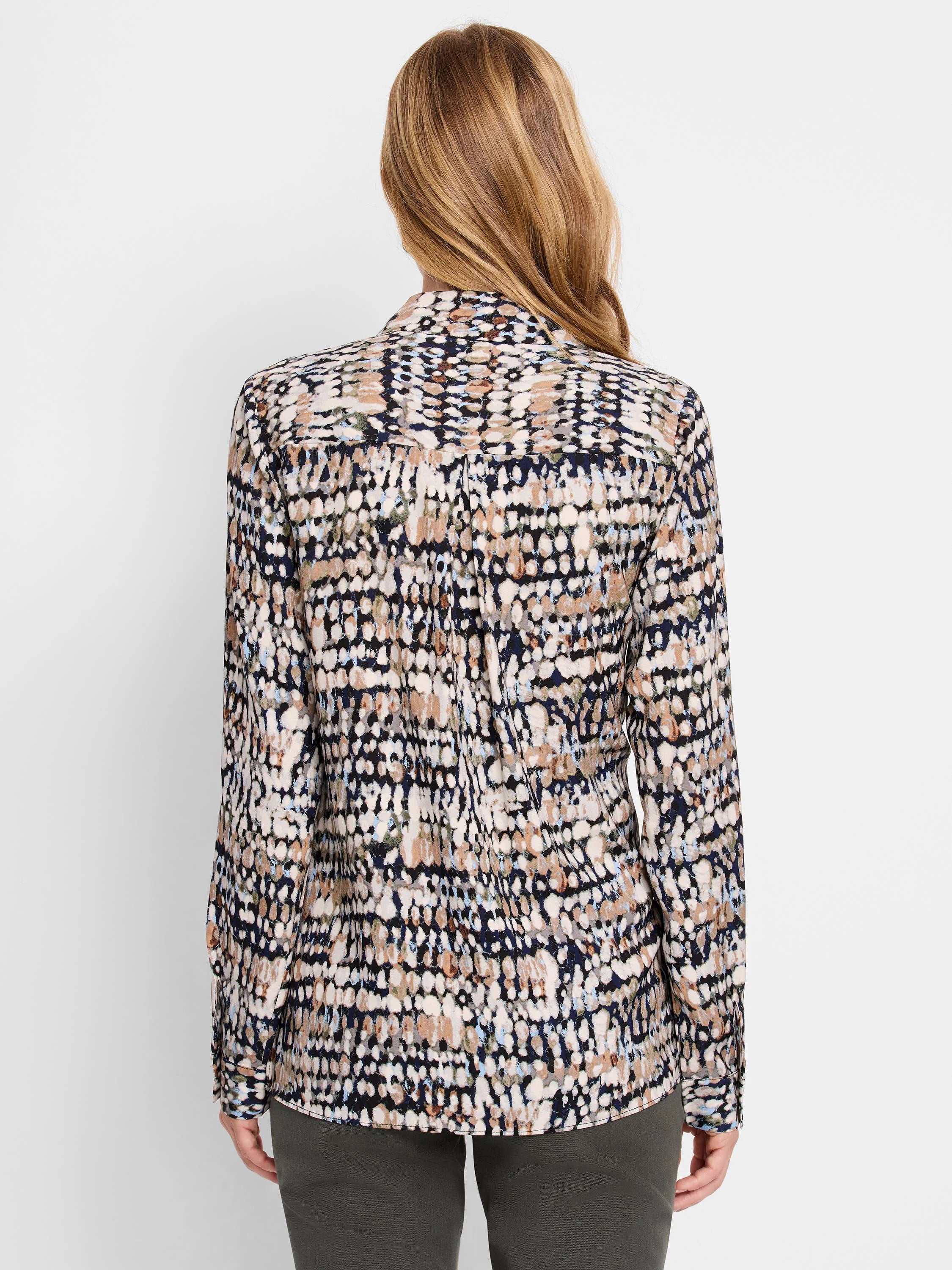 Long-sleeve blouse with irregular dots in cream, tan, light blue, and olive on a navy ground. Back view.