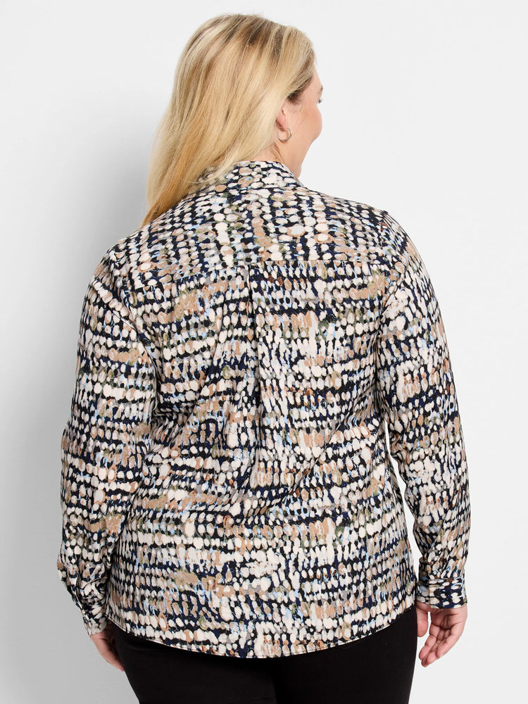 Long-sleeve top with abstract speckled pattern in black, navy, cream, tan, and light blue. Model's back shown.