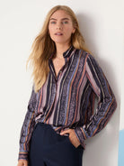 Long-sleeved button-down shirt. Vertical stripes in purple, mauve, brown, green, and black.  Includes animal print accents.