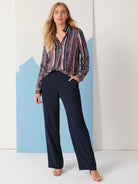 Animal print shirt with vertical stripes in purple, brown, and beige on a dark background.  Long sleeves, collared.