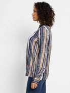 Long-sleeved shirt with vertical stripes in navy, tan, and light gray.  Some stripes incorporate a light animal print.