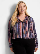 Long-sleeve button-up shirt. Vertical stripes in mauve, orange, purple, and dark teal with animal print accents on a dark...