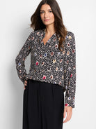 Black long-sleeved blouse.  Multicolored spotted pattern: beige, brown, red, blue. V-neck.