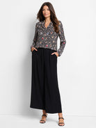 Black long-sleeved blouse with multicolored spotted pattern.  V-neck.