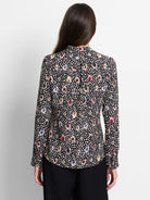 Black long-sleeve top with multicolored spotted pattern.  Beige, brown, blue, and red spots on a dark background.