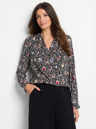 Black top with multicolored spotted pattern; beige, brown, blue, and red spots.  Long sleeves, V-neck.