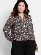 Black long-sleeve blouse.  Multicolored spotted pattern includes beige, red, brown, and blue. V-neck.