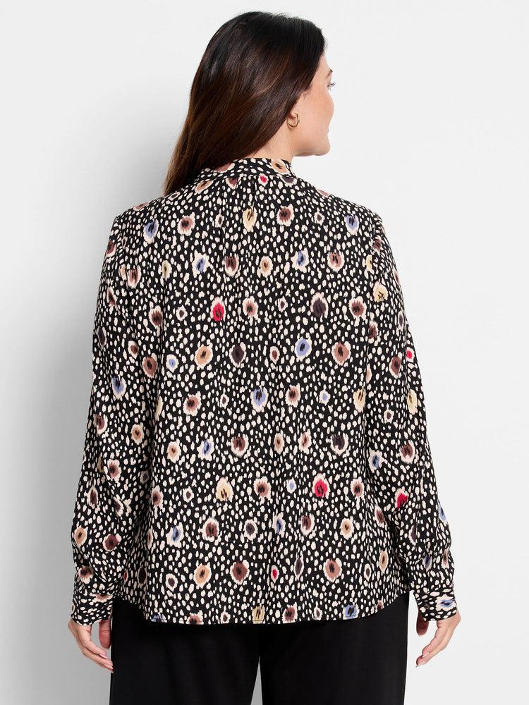 Black long-sleeve blouse.  Features a multicolored spotted pattern in beige, brown, red, and blue on a black background. ...