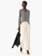 Off-white top with dark-spotted pattern, long sleeves, and V-neck.