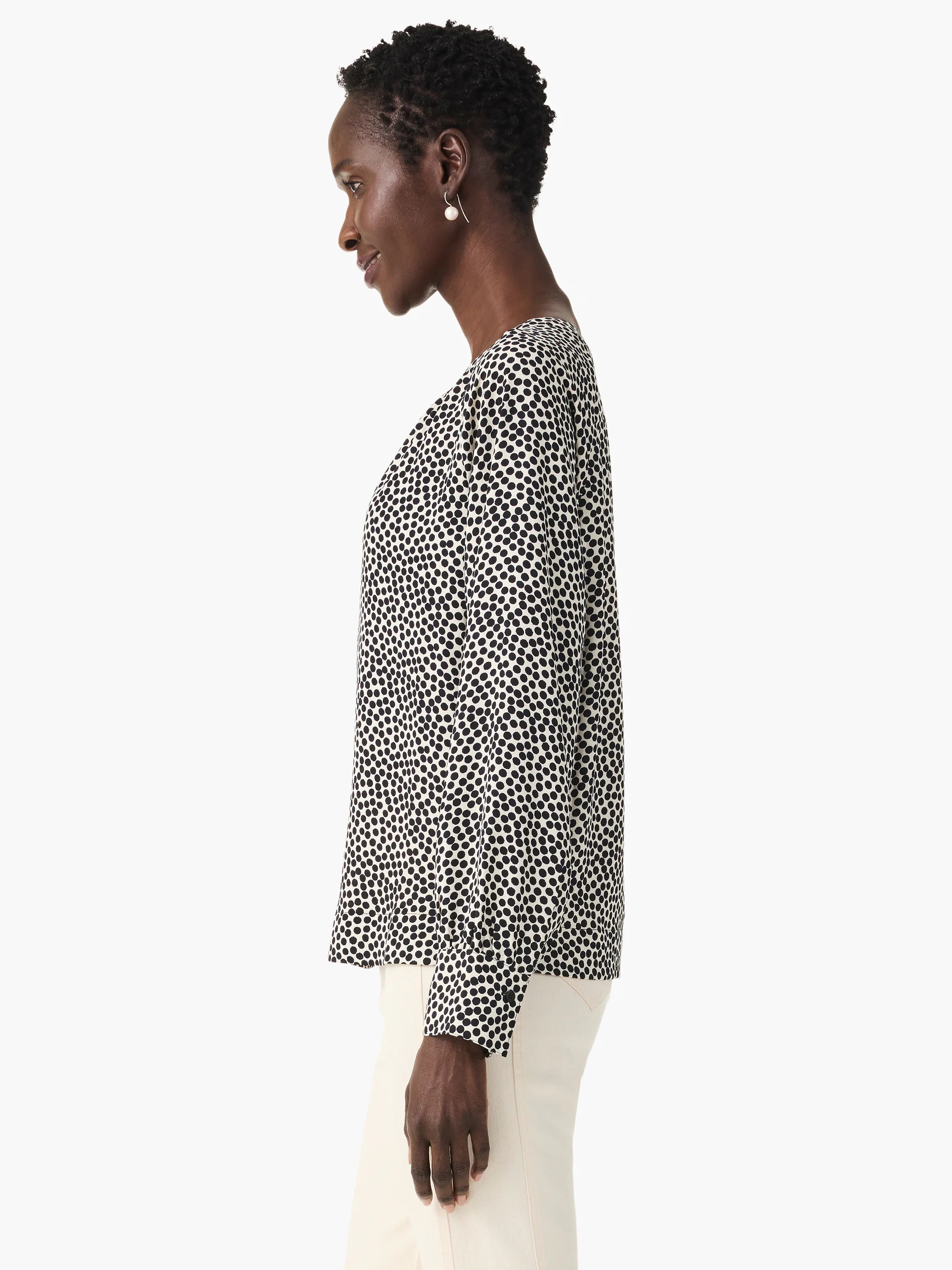 Off-white top with dark-navy scattered dots, long sleeves, and a v-neck.