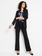 Black blazer, slightly flared black pants, and a blue, white, and purple abstract print blouse.  Model is wearing black...