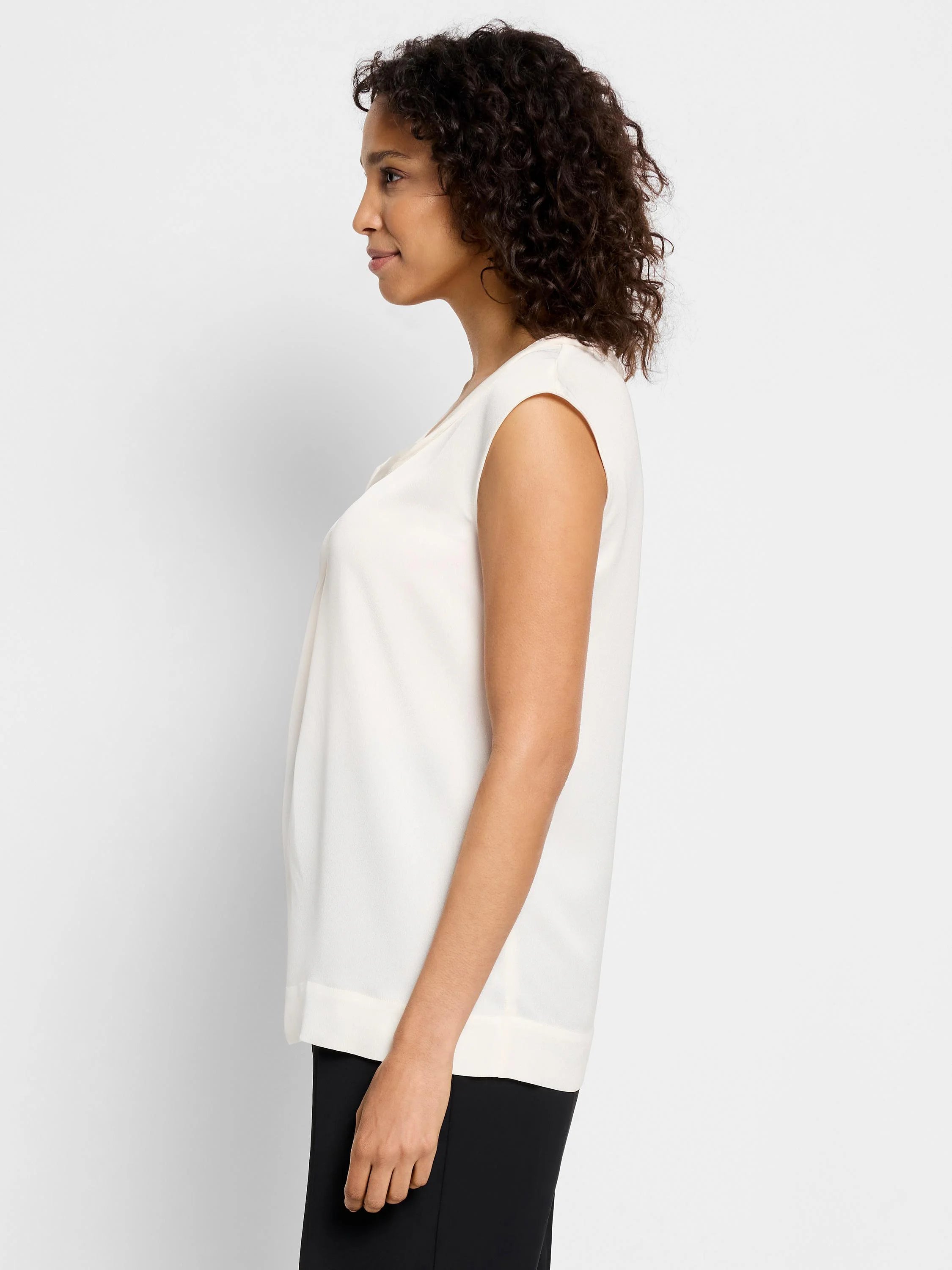 Off-white sleeveless jacket;  V-neck, slightly draped.