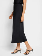 Black midi crepe slip skirt; A-line silhouette.