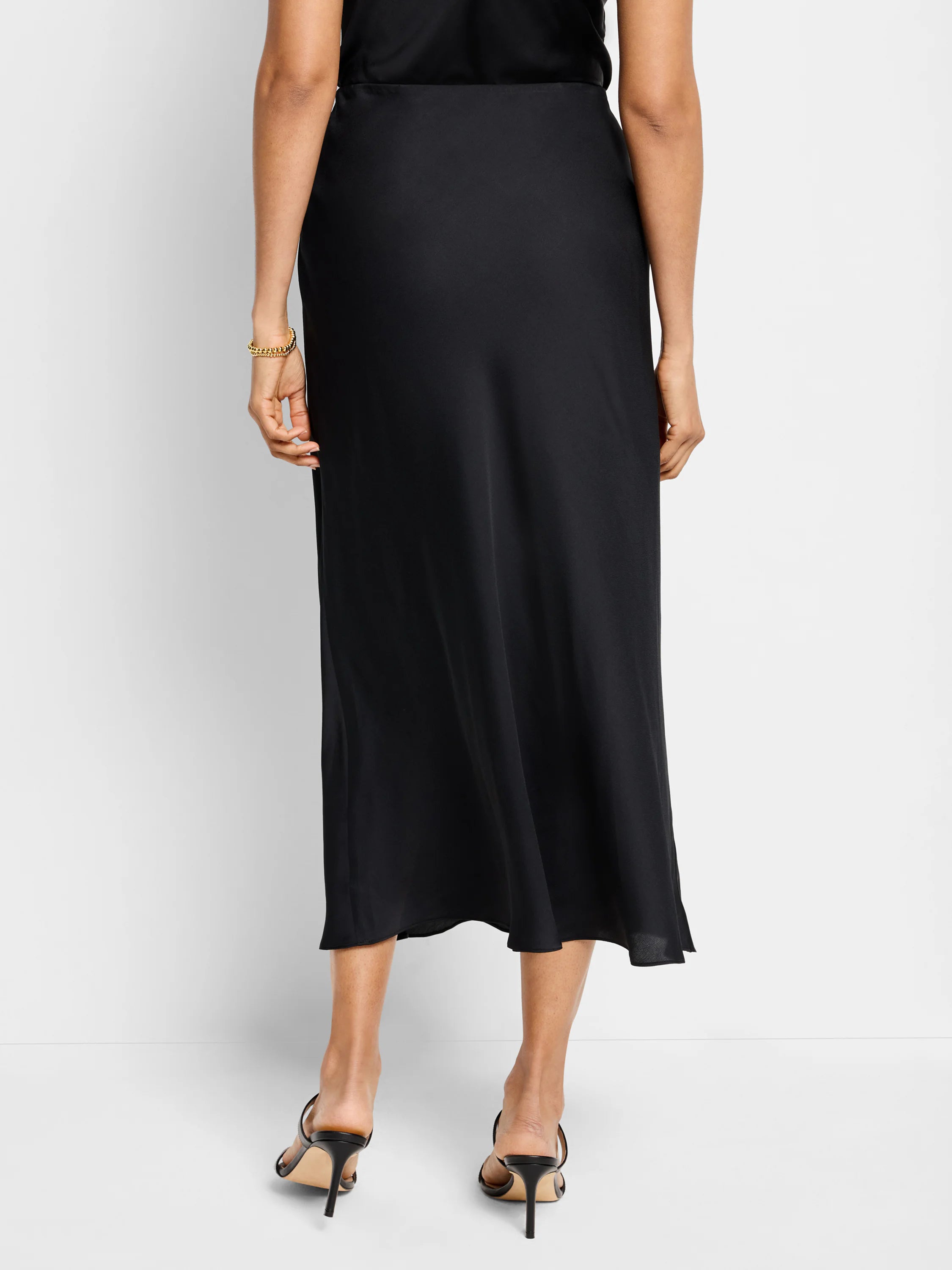 Black midi slip skirt, bias cut, flowing hemline.