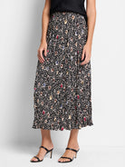 Black pleated midi skirt with multicolored spotted pattern.  Beige, brown, red, and blue spots on black background.
