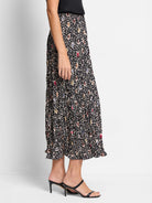 Black pleated midi skirt with multicolored spotted pattern.  Beige, brown, blue, and red spots.