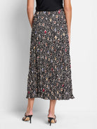 Black pleated midi skirt with multicolored spotted pattern.  Beige, brown, blue, and red spots.