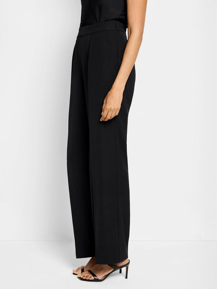Black wide-leg trousers, shown on a model.  High-waisted with center pleats.  Simple, solid color.