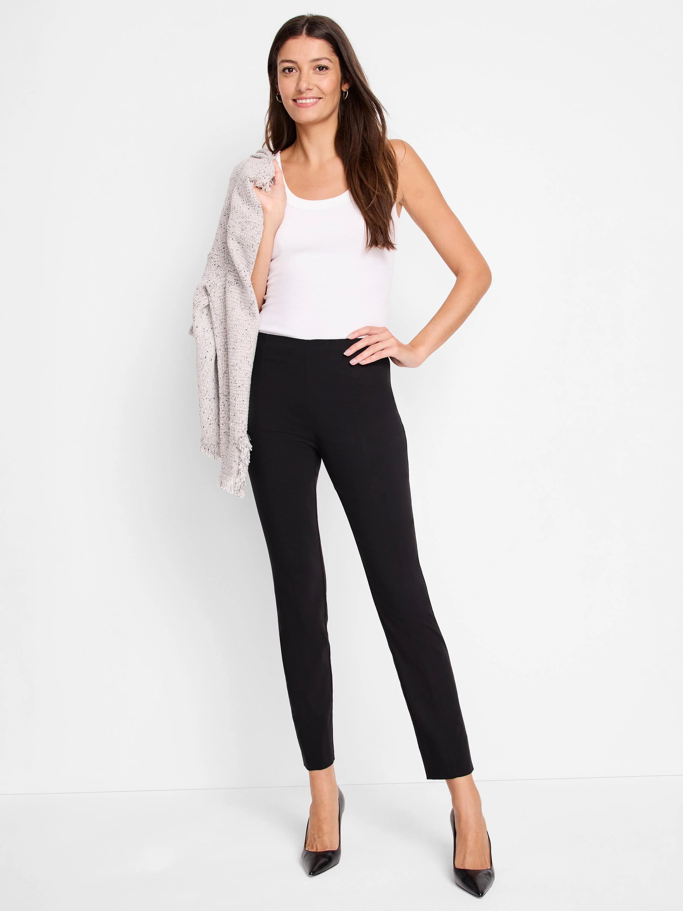 Black slim-leg pants on a model.  The pants have a high waist.