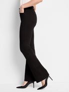 Black bootcut jeans; high-rise. Shown on a model wearing black heels.