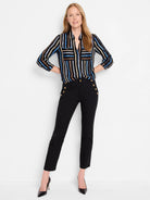 Black cropped pants with gold buttons;  model wears a black, blue, and beige striped shirt.