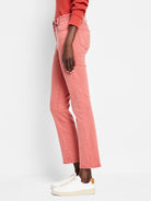 Faded coral straight ankle jeans on a model.