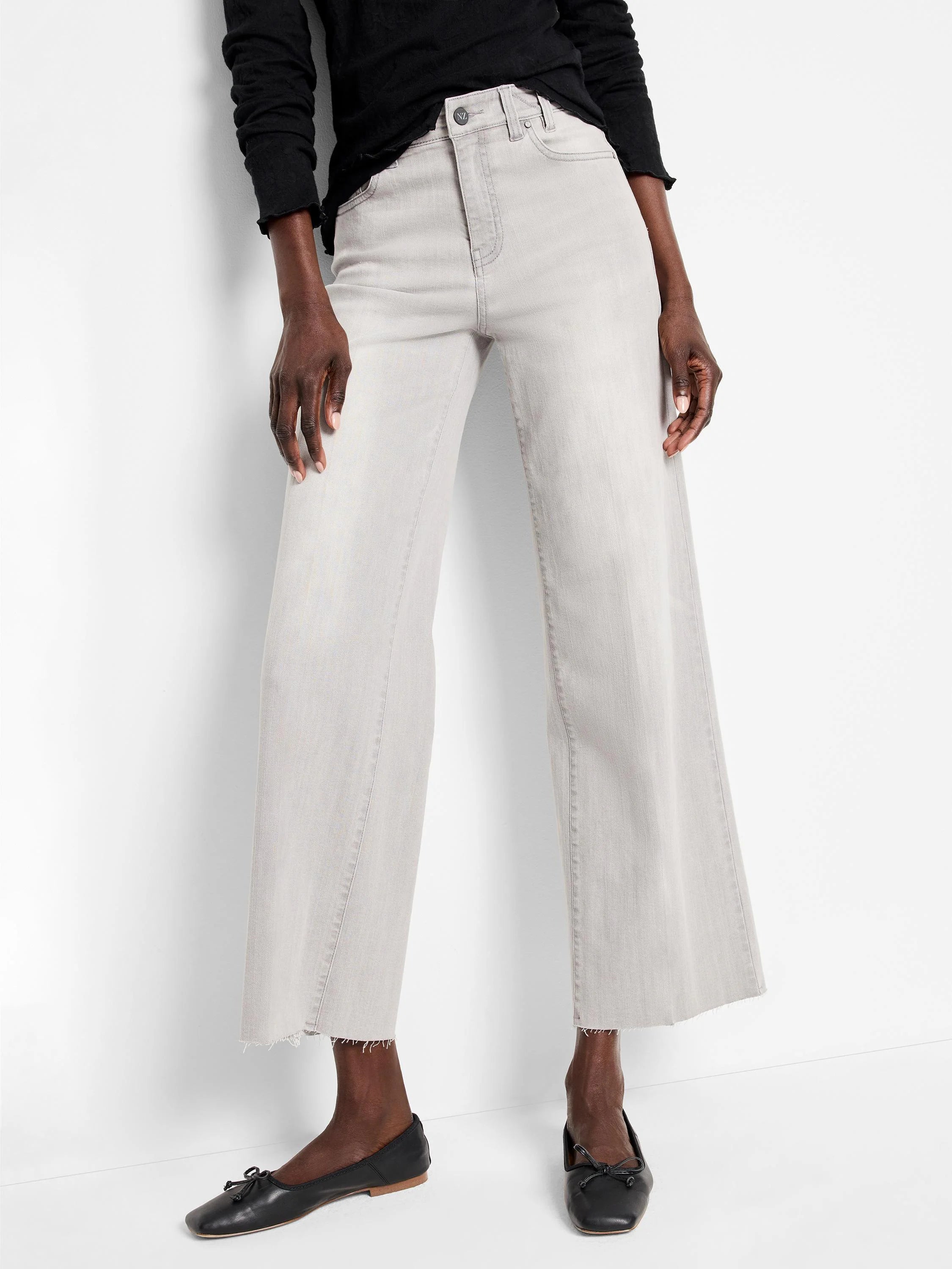 Light grey wide leg jeans, cropped above ankle, with a frayed raw hem. Button fly and front pockets visible.