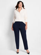 Navy blue straight-leg pants on a model.  The pants have a mid-rise and are shown with a cream-colored shirt.