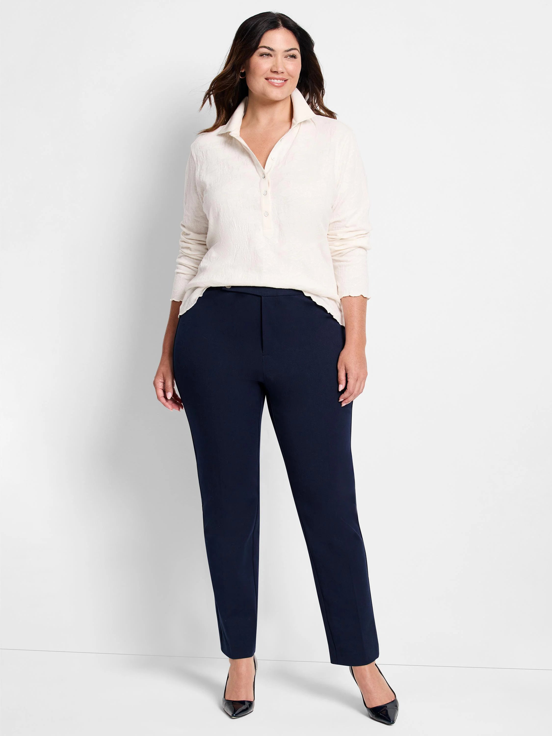 Navy blue straight-leg pants on a model.  The pants have a mid-rise and are shown with a cream-colored shirt.