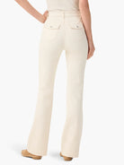 Cream bootcut jeans, back view on model. Features high waist, two flap pockets with silver buttons.