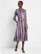 Midi shirt dress with vertical stripes in purple, pink, orange, and brown.  Features a self-tie belt and pockets.