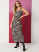 Black midi dress with multicolored spotted pattern, V-neck, sleeveless, belted waist.
