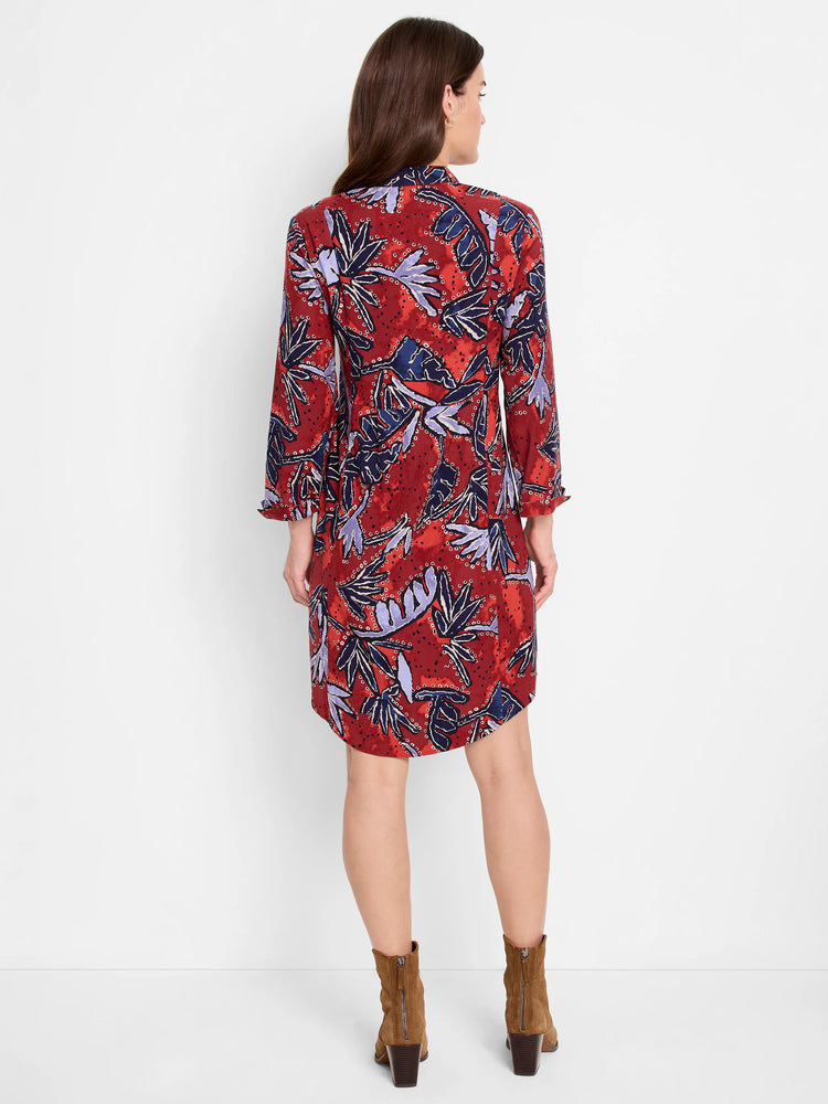 Back view: Knee-length, red-brown collared dress with long sleeves. Features blue and periwinkle leaf patterns.
