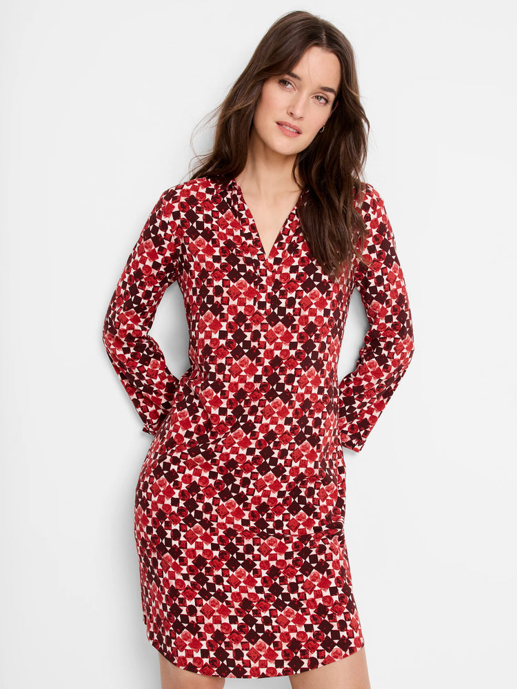 Red and burgundy geometric print mini dress with long sleeves and V-neck.